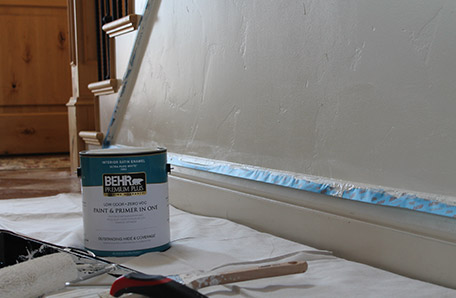 The baseboard is taped and ready to paint