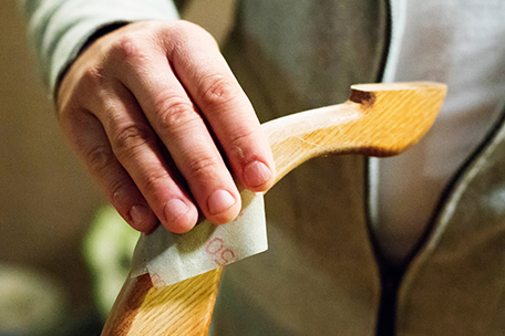 Hand sanding a table leg
