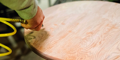 Blowing dust off the table top with an air hose