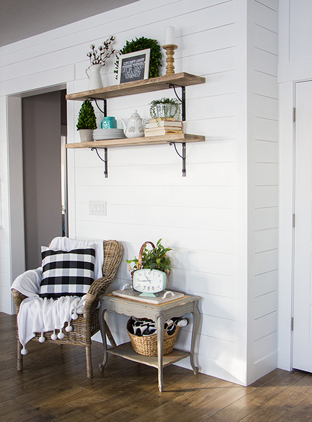 Finished shiplap wall with shelving and furniture