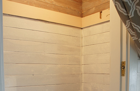 One coat of paint on the raw cedar wall