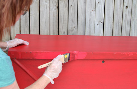 Applying a second coat of paint to the chest