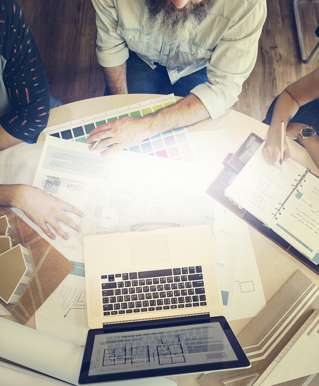 Desk with seated people reviewing a laptop as they choose colors small size