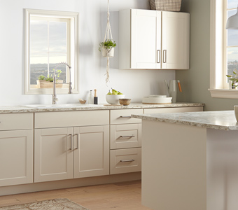 Cream colored kitchen with shaker cabinets and gray marble counter tops.