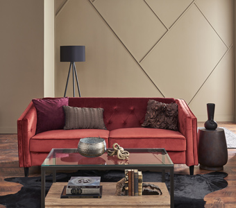 Living room with red couch and beige walls with modular accent feature.